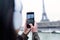 Woman taking photograph of Eiffel tower from the ri