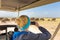 Woman taking photos on african wildlife safari. Amboseli, Kenya.