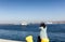 Woman taking photos of the bay of San Diego while sitting down a