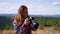 Woman taking photos on camera in mountains. Photographer shooting landscape