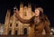 Woman taking photos in front of Duomo in evening , Milan