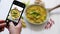 Woman taking a photos with mobile phone of delicious fried rice with chicken served in pan