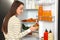 Woman taking pickles out of refrigerator