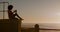 Woman taking picture on beach at sunset