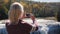 A woman is taking a picture of a waterfall in Letchworth State Park.