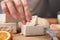 Woman taking piece of compressed yeast at table, closeup