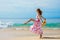 Woman taking step forward on the beach.