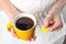 Woman taking tea bag out of cup with beverage