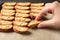 Woman taking traditional Italian almond biscuit Cantucci from baking sheet, closeup