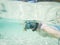 woman taking an underwater selfie while snorkeling in crystal clear tropical water