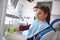 Woman taking water while sitting in dental chair