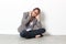 Woman talking on cell phone sitting alone on office floor over sparse