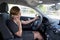 Woman talking happy on mobile phone while holding car steering wheel driving distracted