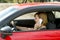 Woman talking happy on mobile phone while holding car steering wheel driving distracted