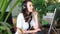 Woman talking on headset in office with client surrounded by plants