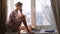 Woman talking on her phone sitting on window sill