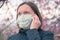Woman talking on mobile phone with respiratory face mask