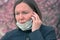 Woman talking on mobile phone with respiratory face mask