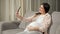 Woman talks via videocall using phone and stroking belly
