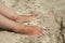 Woman tanned legs on sand beach. Woman In Relaxation On Tropical Beach with sand.