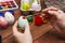 A woman with a tassel paints Easter eggs. Preparing decorations for Easter, creativity with children, traditional symbols.