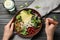 Woman with tasty pear salad at black table, top view