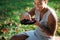 Woman with tattoo on arm eating yummy strawberries