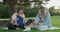 Woman teacher and girl student teenager sitting on the grass in park talking, testing, learning