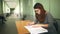 Woman teacher glasses checks homework sitting desk