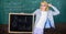 Woman teacher holds blackboard back to school inscription on chalkboard background. Apply for sensational educational