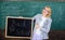 Woman teacher holds blackboard back to school inscription on chalkboard background. Apply for sensational educational