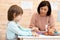 Woman teacher play with preschooler child in day care center