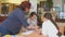 Woman Teacher with primary school students. Schoolgirl writes on paper