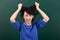 Woman teacher in stress posing on chalk board background, touch her hair