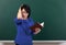 Woman teacher in stress posing by chalk Board, learning concept, green background, Studio shot