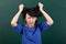 Woman teacher in stress posing by chalk Board, tears her hair, learning concept, green background, Studio shot