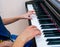 A woman teaches little boy to play the piano. Playing together.