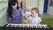 Woman teaches little girl to play on synthesizer