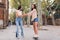 woman teaching her friend to ride a skateboard