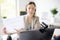 Woman is teaching language with laptop computer, camcorder and headphone at home. Teacher is having video conference chat with