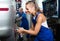 Woman technician fitting new tires to car at workshop