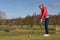 Woman teeing off at a golf course