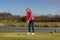 Woman teeing off at a golf course