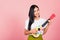 Woman teen confident smiling face hold acoustic Ukulele guitar