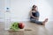 Woman or teenager girl sitting on ground alone worried at home suffering nutrition eating disorder