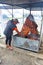 A woman tends to roasting meat at a restaurant on the side of a