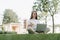 Woman texting laptop, sitting on the grass