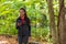 Woman texting using mobile phone on outdoor walk hike walking in forest nature path on trail woods background. Happy