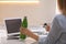 Woman with thermo bottle working at table in modern office, closeup