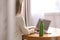 Woman with thermo bottle working at table in modern office, closeup